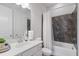 Well-lit bathroom with a white vanity, toilet, a shower-tub combo with dark marble tile surround, and a curtain at 6320 Halcyon Garden Dr, Alpharetta, GA 30005