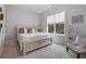 Cozy bedroom showcasing a large window, neutral carpet, stylish furnishings, and a comfortable bed with a padded headboard at 6320 Halcyon Garden Dr, Alpharetta, GA 30005