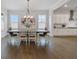 Spacious dining room features hardwood floors, modern chandelier, and views to the bright open kitchen at 6320 Halcyon Garden Dr, Alpharetta, GA 30005