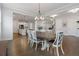 Open concept dining area with hardwood flooring and views to kitchen and living room with fireplace at 6320 Halcyon Garden Dr, Alpharetta, GA 30005