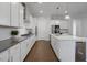 Gourmet kitchen boasts white cabinets, stainless appliances, stone counters, and a large island at 6320 Halcyon Garden Dr, Alpharetta, GA 30005
