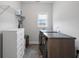 Functional laundry room featuring modern washer/dryer, gray tile floor and ample storage with white shelving and cabinets at 6320 Halcyon Garden Dr, Alpharetta, GA 30005