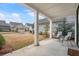 Comfortable outdoor seating with a view of the tree-lined backyard in a covered outdoor living area at 6320 Halcyon Garden Dr, Alpharetta, GA 30005