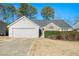 White house with a two-car garage and manicured lawn at 1013 Bluecoat Cir, Hampton, GA 30228