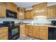 Galley kitchen with wood cabinets and black appliances at 110 Elk Ridge Dr, Social Circle, GA 30025