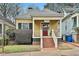 Charming yellow home featuring a welcoming front porch with swing and brick stairs at 725 Oakland Se Ave, Atlanta, GA 30315