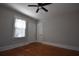 Empty bedroom with hardwood floors, gray walls, white trim, ceiling fan, and a window with blinds at 1830 W Taylor Ave, Atlanta, GA 30344
