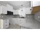 Updated kitchen with white cabinets, granite countertops, stainless steel appliances, and tiled backsplash at 1830 W Taylor Ave, Atlanta, GA 30344