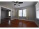 Living area with hardwood floors, natural light from the windows and an opening into another room at 1830 W Taylor Ave, Atlanta, GA 30344