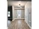 A bright entryway with wood-look flooring, a modern light fixture, and a decorative front door at 4863 Amsler Rd, Ellenwood, GA 30294