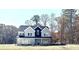 Charming two-story home with gray siding, black accents, large windows and an inviting front porch nestled in a wooded area at 4863 Amsler Rd, Ellenwood, GA 30294