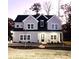 Charming two-story home with gray siding, black accents, large windows and an inviting front porch illuminated at twilight at 4863 Amsler Rd, Ellenwood, GA 30294
