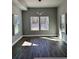 Bright living room featuring hardwood floors and large windows overlooking a wooded backyard at 4863 Amsler Rd, Ellenwood, GA 30294