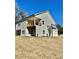 Side view of a gray two-story home featuring an attached two-car garage and a second-story balcony at 4863 Amsler Rd, Ellenwood, GA 30294