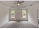 Spacious bedroom with carpet, ceiling fan, and two large windows at 1442 Casteel Lake Ln # 277, Buford, GA 30518