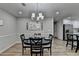 A well lit dining room with a round table, seating for six, and an open concept view to the kitchen at 1606 Fieldgreen Overlook, Stone Mountain, GA 30088