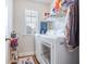 Bright laundry room features washer, dryer, and ample shelving at 1567 Brunswick St, Lithia Springs, GA 30122