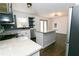 Modern kitchen with white cabinets, granite island, and dark tile backsplash at 2105 Fellowship Rd, Tucker, GA 30084
