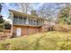 Rear view of a home with a large screened porch and brick exterior at 3856 Woodyhill Dr, Lithonia, GA 30038