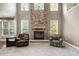 Bright living room featuring a stone fireplace and a view of the staircase at 120 Fountain Oak, Villa Rica, GA 30180