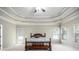 A bright main bedroom featuring tray ceilings, carpet flooring, and three windows at 120 Fountain Oak, Villa Rica, GA 30180