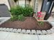 Landscaped yard with decorative stone edging, mulched flower beds, and 'Welcome' sign at 1370 Long Acre Dr, Loganville, GA 30052