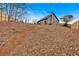 Sloped backyard with leaf covered ground and a wooden fence at 65 Centerport Dr, White, GA 30184