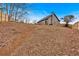 Sloped backyard with leaf covered ground and a wooden fence at 65 Centerport Dr, White, GA 30184