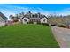 House exterior showcasing a spacious lawn and a long driveway leading to the home at 65 Centerport Dr, White, GA 30184