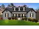 Stunning two-story home with white brick exterior, black accents, and a manicured lawn at 65 Centerport Dr, White, GA 30184