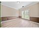 Dining room with neutral paint, wainscoting, light wood floors and natural light from a window at 1131 Orr Rd, Jonesboro, GA 30238