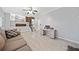 Living room featuring a neutral color scheme, modern ceiling fan, and a view of the staircase and kitchen at 1131 Orr Rd, Jonesboro, GA 30238