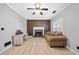 Cozy living room features modern ceiling fan, stone fireplace, and a comfortable sofa for relaxation at 1131 Orr Rd, Jonesboro, GA 30238