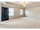 Spacious main bedroom featuring neutral carpet, many windows, and a modern chandelier at 3236 Tallon Sw Ln, Atlanta, GA 30311