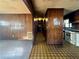 Hallway featuring vintage wood paneled walls and a view of the kitchen with vintage appliances at 5961 John St, Austell, GA 30106