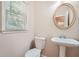 Simple bathroom with pedestal sink, toilet and oval mirror at 3314 Mill Grove Ter, Dacula, GA 30019