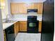 Kitchen with wood cabinets, black appliances, and double sink at 3526 Shepherds Path # 1, Decatur, GA 30034