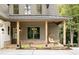 Inviting covered porch with wooden pillars, brick accents, and a cozy seating area at 102 Creekview Ln, Canton, GA 30115