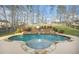 Backyard pool and spa featuring a waterfall feature, lush landscaping, and a surrounding patio at 1947 Greensferry Gln, Lawrenceville, GA 30043