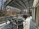 This inviting outdoor deck area features a dining set and comfortable seating, shaded by a pergola and lush trees at 3730 Ashford Ne Pt, Brookhaven, GA 30319