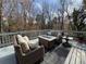 Back deck area furnished with outdoor couches, a fire pit table, and outdoor rug, perfect for relaxing outdoors at 3730 Ashford Ne Pt, Brookhaven, GA 30319
