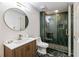 Stylish bathroom featuring a glass shower with green tile and marble floor, complemented by wooden vanity at 3730 Ashford Ne Pt, Brookhaven, GA 30319