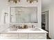 Modern bathroom vanity with double sinks, elegant lighting, and a sleek, frameless mirror at 3730 Ashford Ne Pt, Brookhaven, GA 30319