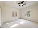 This bright, neutral bedroom features plush carpet, a modern ceiling fan, and sun-filled windows with tree-lined views at 3730 Ashford Ne Pt, Brookhaven, GA 30319