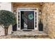 Inviting front entrance with a stone facade, stylish black door and green wreath at 3730 Ashford Ne Pt, Brookhaven, GA 30319