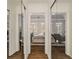 Hallway with mirrored closet doors reflecting the bedroom which has hardwood floors and many windows at 3730 Ashford Ne Pt, Brookhaven, GA 30319