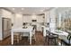 Well-lit kitchen with white cabinetry, stainless steel appliances, eat-in island, and adjacent dining area offering a functional design at 3730 Ashford Ne Pt, Brookhaven, GA 30319