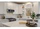 Bright kitchen featuring white cabinets, quartz countertops, stainless steel appliances, and a garden window creating a modern cooking space at 3730 Ashford Ne Pt, Brookhaven, GA 30319