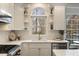 Bright kitchen sink area featuring white cabinets, stylish fixtures, and a view of the outdoors at 3730 Ashford Ne Pt, Brookhaven, GA 30319