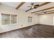 Spacious living area with wooden floors, exposed beams, and abundant natural light from large windows at 3730 Ashford Ne Pt, Brookhaven, GA 30319